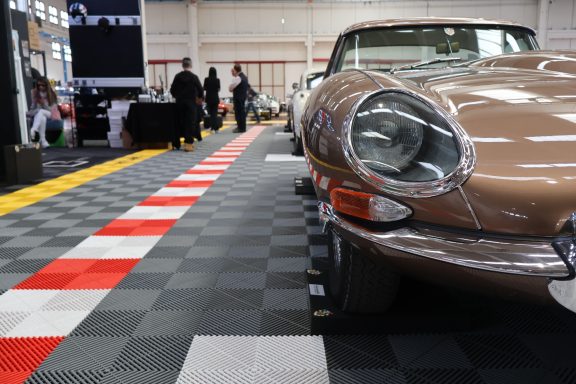 Classical car exhibition with a vintage car on display and checkered flooring.