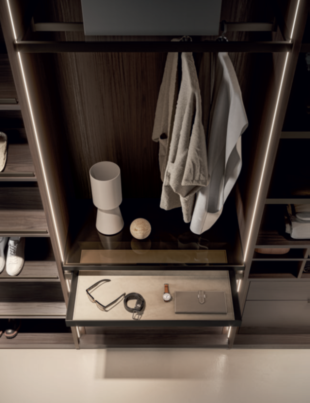 ARMADIO CON CASSETTI PORTA OGGETTI Appendiabiti con camicie, lampada, candela e accessori su un ripiano in legno.