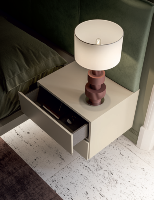 COMODINO SOSPESO Comodino moderno con lampada e cassetto aperto, accanto a un letto.