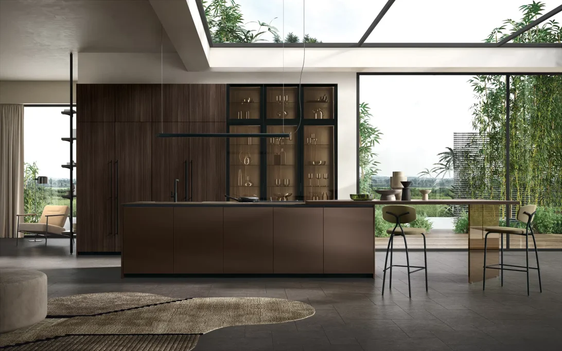 Cucina moderna con armadietti scuri, fronte di legno e vista su un giardino verde.