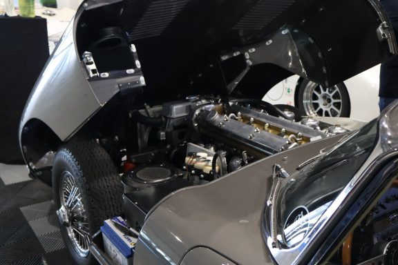 Motorsports car with hood open, showcasing its engine and internal components.
