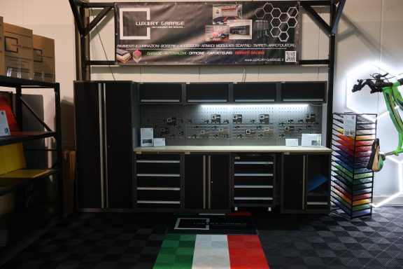 Banco di lavoro con cassetti, illuminazione e decorazioni italiane sul pavimento.