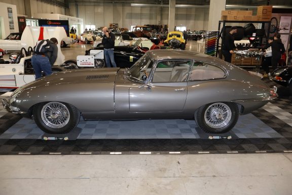Automobile in a garage, featuring a sleek, gray vintage sports car.