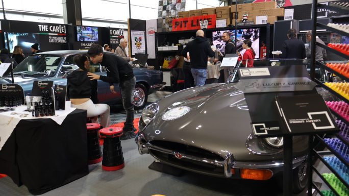 Espacio de exhibición con coches clásicos y decoración colorida. 