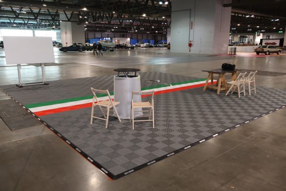 Palco vuoto con sedie e tavolo, decorato con striscia verde, bianca e rossa.
