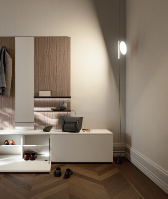 INGRESSO APPENDIABITI Modern bedroom corner with wooden accents, minimalist furniture, and soft lighting.