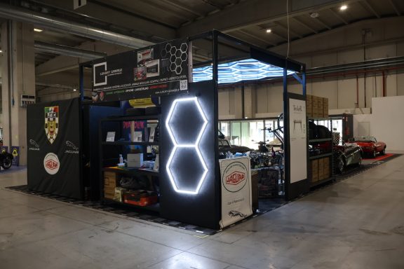 Stand with racing-themed decor and cars, featuring a prominent glowing number 8.