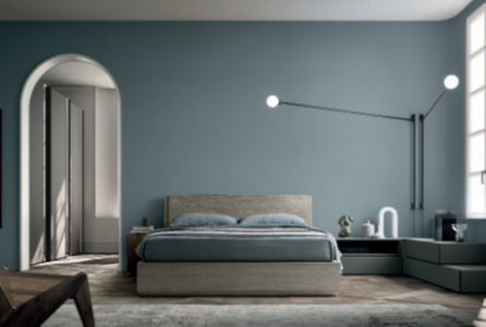 CAMERA DA LETTO CON LETTO A TERRA Camera view of a modern bedroom with a blue wall, bed, and minimalist decor.