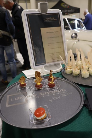 Platter of gourmet appetizers displayed at a culinary event, including small bites and sauces.