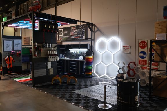 Spacious exhibition booth with tools and colorful hexagonal lights.