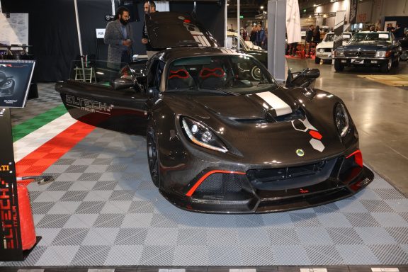 Sport car displayed at an auto show with a glossy black finish and red accents.