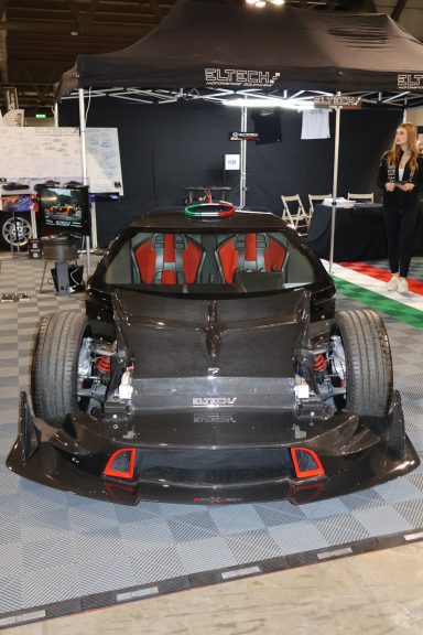 Auto da corsa con carrozzeria in fibra di carbonio e sedili rossi.
