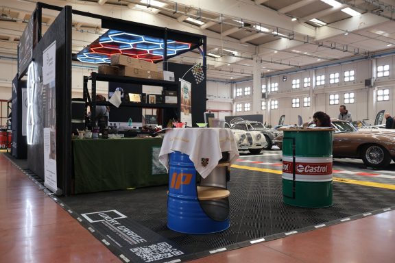 Esposizione di auto con un'area di stand e barili decorati.